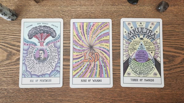 Three tarot cards side by side on a wooden surface.